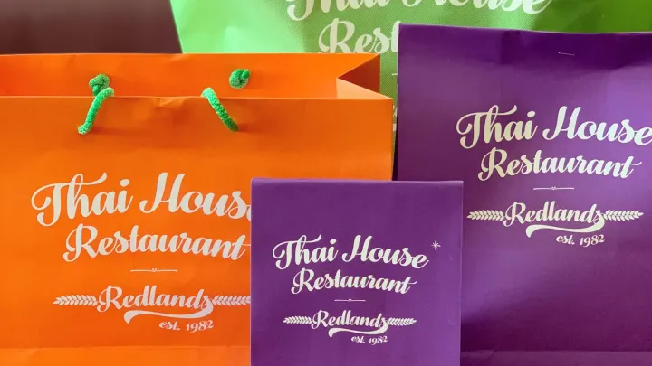 Thai House Redlands catering bags in purple, orange, and green ready for pickup