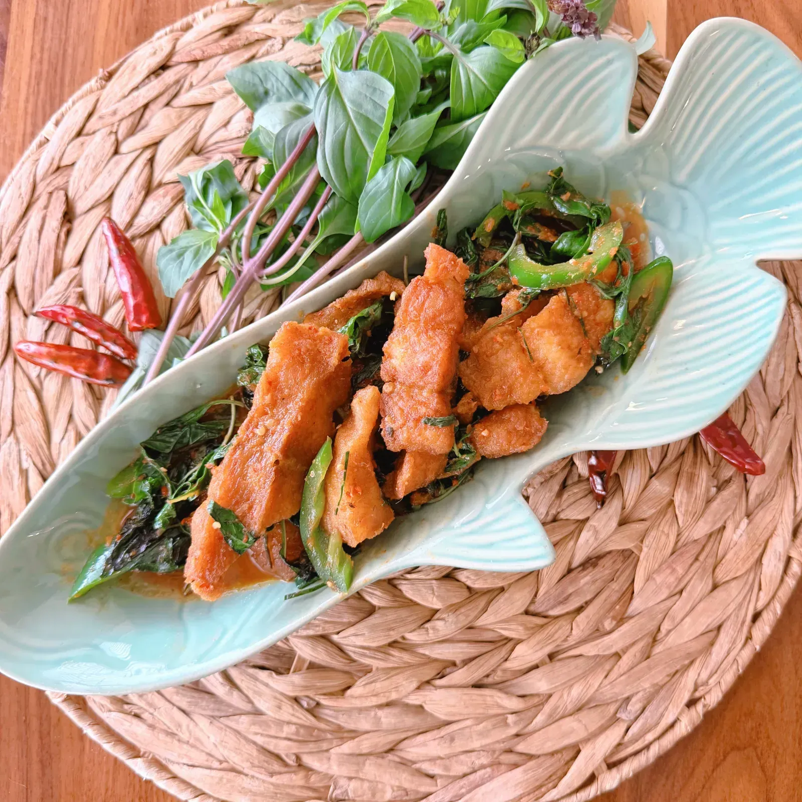 Fried catfish fillet simmered in Thai House red curry sauce on a plate