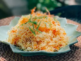 Crispy Mee Krob rice noodles glazed in sweet tangy sauce with shrimp and chicken