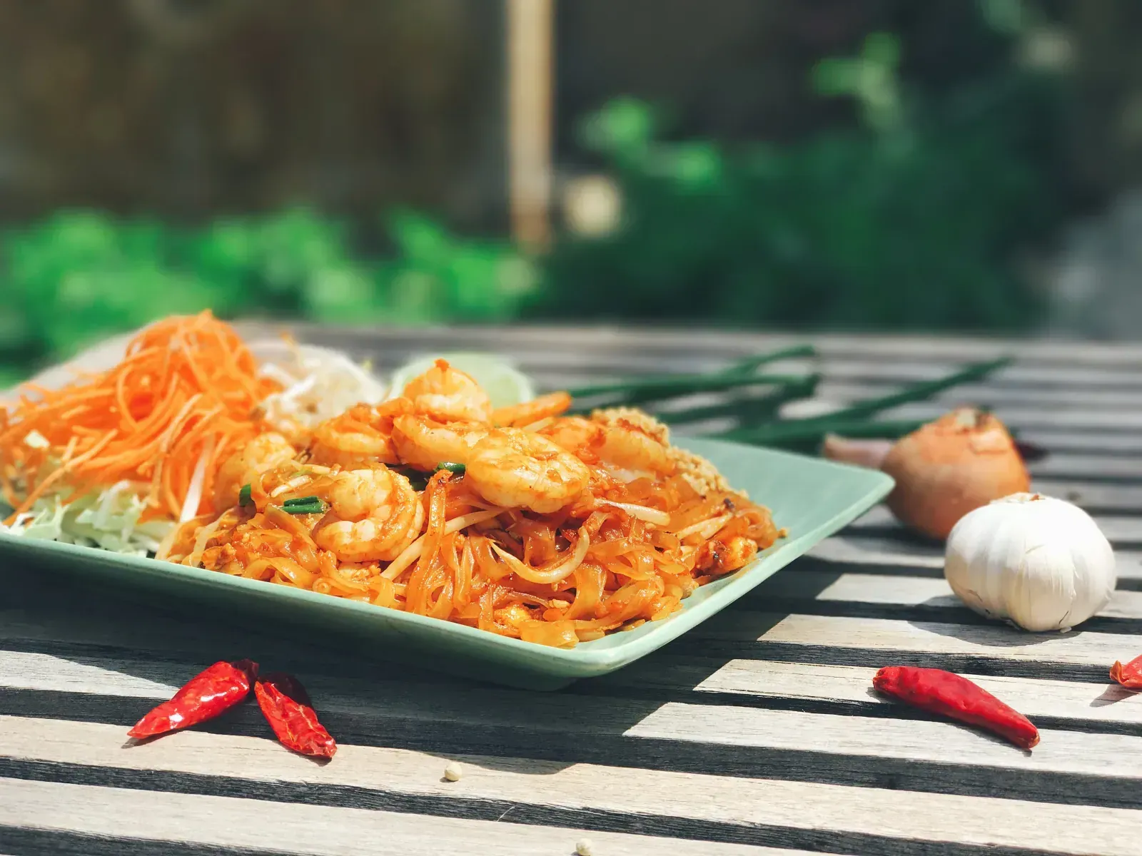 Pad Thai with shrimp, bean sprouts, and fresh lime served on a celadon plate