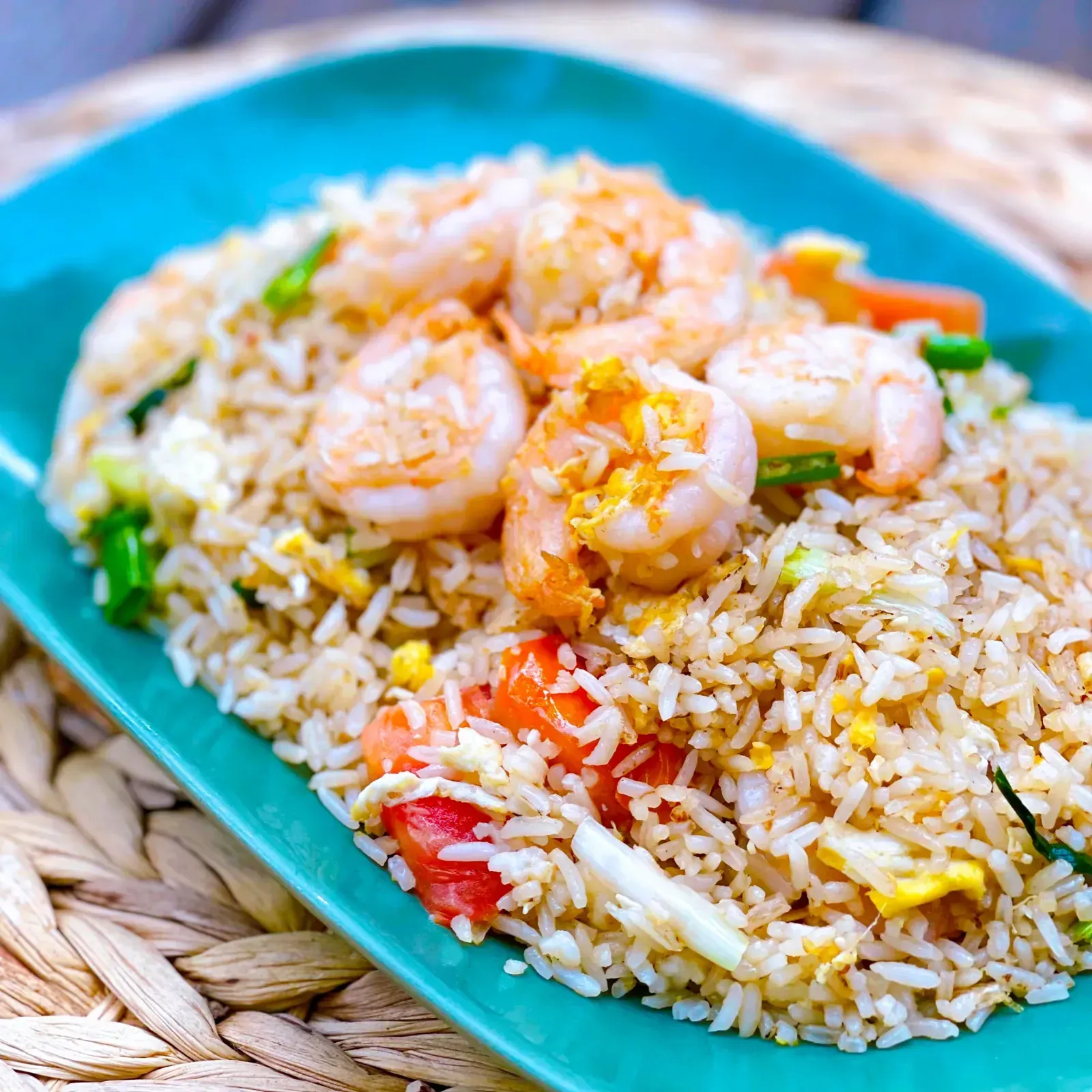 Thai shrimp fried rice with scallions, onions, tomatoes and egg on a plate